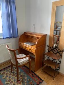 an old wooden desk with a chair and a mirror at Nationalpark Lobau Wohnung in Groß-Enzersdorf