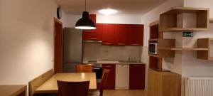 cocina con armarios rojos y mesa de madera en Apartment Markič, en Bohinj