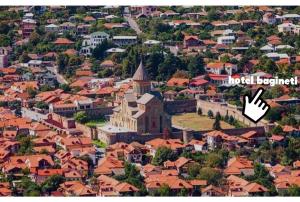a view of a city with a hand pointing to a building at Hotel Bagineti in Mtskheta