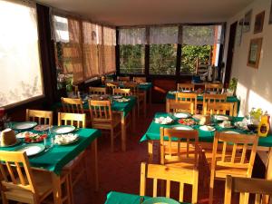 una sala da pranzo con tavoli e sedie verdi di Biebrza 24 a Sztabin