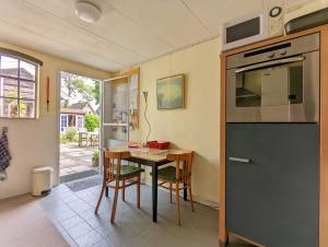a kitchen with a table with chairs and a microwave at De Slaapmus in Boven-Leeuwen