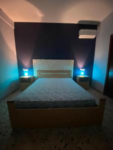 - une chambre dotée d'un lit avec des lumières bleues dans l'établissement 2 Min dal Mare - Alloggio con Patio Privato e BBQ, à Triscina