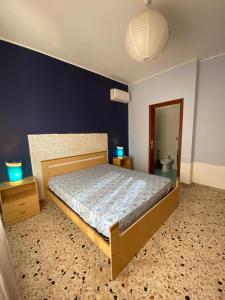 - une chambre avec un lit et un mur bleu dans l'établissement 2 Min dal Mare - Alloggio con Patio Privato e BBQ, à Triscina