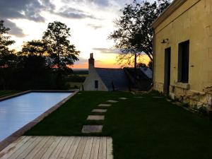 a backyard with a swimming pool next to a building at La Rigottiere in Huismes