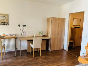 een kamer met een bureau en een tafel met een stoel bij Schönes Apartment in perfekter Lage in Mönchengladbach