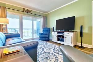 a living room with a couch and a flat screen tv at Water View 506 in Clearwater Beach