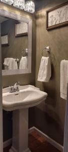 a bathroom with a sink and a mirror and towels at J.Creek Retreat, creekside townhouse +1 car garage in Maggie Valley