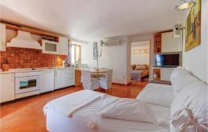 a kitchen and living room with a bed and a table at Cozy Apartment In Mali Losinj With Kitchen in Mali Lošinj