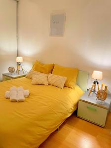 een groot geel bed in een kamer met 2 lampen bij Appart'Bohème *CLIM*PARKING*WIFI*CONFORT in Blagnac