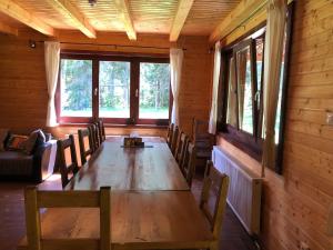 Casa de Vacanta Dintre Brazi في توبليتا: غرفة طعام مع طاولة وكراسي خشبية
