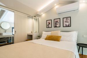 1 dormitorio con 1 cama blanca grande y lavamanos en Bright & elegant loft suite in the city center, en Zakynthos