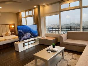 ein Wohnzimmer mit einem großen TV und einem Sofa in der Unterkunft وشل للشقق المخدومة واحة الغروب سابقا in Tanomah