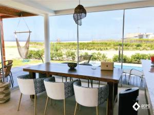 una sala da pranzo con tavolo, sedie e computer portatile di HOP MALIBU exclusiva frente al mar de Chincha a Chincha Baja