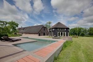 a house with a swimming pool and a barn at Posthoorn Lodge in Woerden