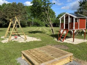 a playground with a slide and a play house at Heidegut Eschede Reitsportanlage und Feriendorf in Eschede