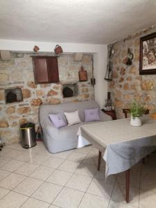ein Wohnzimmer mit einem Sofa und einem Tisch in der Unterkunft Dalmatinska kuća za odmor in Tučepi