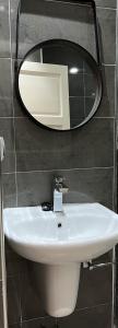 baño con lavabo y espejo en la pared en Tiwaline Tarsime App D, en Sidi Ifni