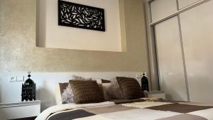 a bedroom with a bed with a picture on the wall at Tiwaline Tarsime App D in Sidi Ifni
