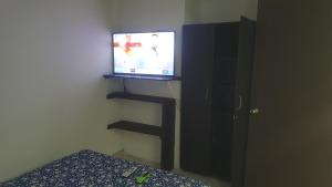 Habitación con TV en la pared y cama en cerca aeropuerto embajada EEUU fotos huellas visa, en Bogotá