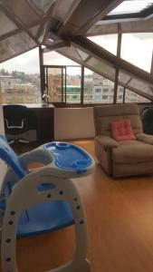 una silla azul y blanca en una habitación con sofá en cerca aeropuerto embajada EEUU fotos huellas visa, en Bogotá