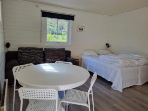 a room with a bed and a table and chairs at Skahjem Gard in Aurland