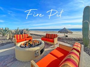 a fire pit on the beach with two couches at Upscale Beachfront Condo with Tub and Private Beach in Playa Encanto