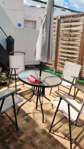 un patio con mesa, sillas y sombrilla en APARTAMENTO CENTRO SANTA CATALINA, en Sevilla
