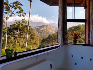 a bathroom window with a view of a mountain at Pousada Mirante do Céu in Visconde De Maua