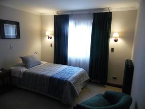 a hotel room with a bed and a television at Hotel Isla Rey Jorge in Punta Arenas