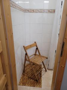 een houten stoel in een badkamer met douche bij Westerslag in Lathen