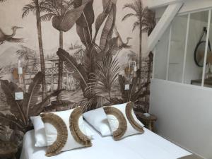 a bedroom with a mural of palm trees at La grange de l ocean SPA in Linxe