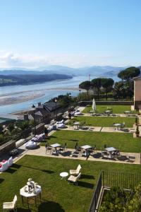 un parque con mesas de picnic y vistas al agua en Parador de Ribadeo, en Ribadeo