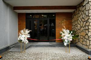 a front door of a building with flowers in front at Hill Hotel in Kutaisi