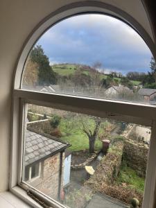 an arched window with a view of a yard at Six on Castle in Tiverton