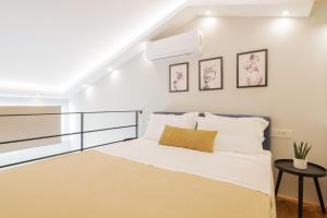 ein weißes Schlafzimmer mit einem Bett und einer Treppe in der Unterkunft Stylish & elegant loft suite in the city center in Zakynthos