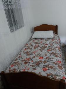 1 cama con edredón de flores en un dormitorio en Guest House Emanueli, en Tropojë