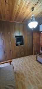 a living room with wooden cabinets and a television at Tonia’s & Chris House in Kalliópi
