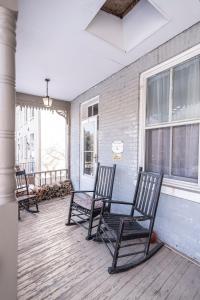 a porch with three rocking chairs on a house at Armory Quarters A in Harpers Ferry
