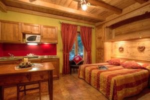 a bedroom with two beds and a kitchen in a room at B&B Residence Checrouit in Courmayeur