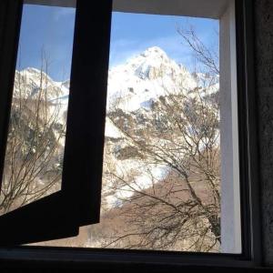 uma vista para uma montanha coberta de neve a partir de uma janela em Guest House Emanueli em Tropojë