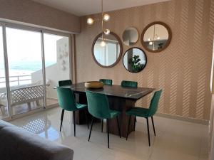 a dining room with a table and chairs and mirrors at a pie de playa con hermosa vista by G P S rentas in Mazatlán