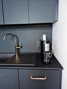 a kitchen counter with a coffee maker and a sink at Apartament Węgorzewo in Węgorzewo