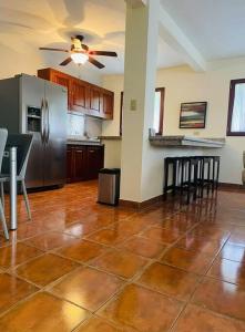 a kitchen with a stainless steel refrigerator and a table at Sueños de Amor! Hermoso y Acogedor lugar in Quepos