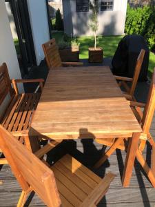 una mesa de picnic de madera y sillas en un patio en Villa Ohana in Pobierowo 300 m from the beach en Pobierowo