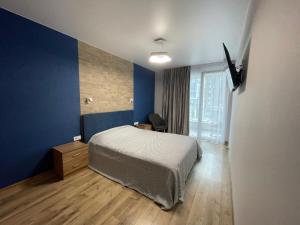 um quarto com uma cama e uma parede azul em Resident Hall em Lviv