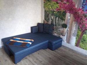 Ferienwohnung Radebeul Self Check-in في راديبول: أريكة زرقاء جالسة على شرفة بها زهور