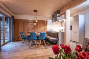eine Küche und ein Esszimmer mit einem Tisch und blauen Stühlen in der Unterkunft Griena NaturChalets **** in Mayrhofen
