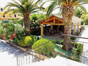 a resort with a palm tree and a restaurant at Villa Fondas Roda in Roda