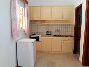 a kitchen with a white refrigerator and a microwave at Villa Fondas Roda in Roda