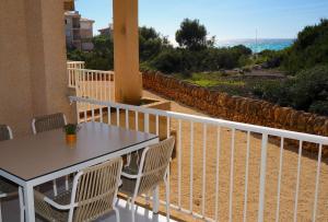 a balcony with a table and chairs and the ocean at Apartments Es Trenc in Ses Covetes